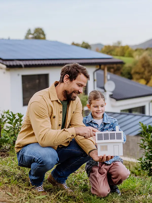 Vater und Kind mit Solaranlage im Hintergrund